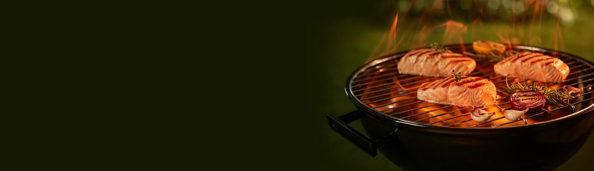 Kawałki łososia z warzywami grillowane na ogniu na czarnym grillu.